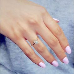 a woman's hand with pink nail polish and a diamond ring