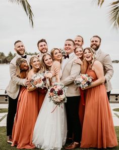 a group of people standing next to each other in front of a body of water