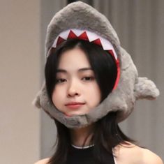 a woman wearing a shark hat with her mouth open