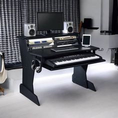 an electronic keyboard sitting on top of a desk next to a computer monitor and speakers