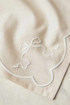 a close up of a cloth with white thread on it and a stitched design