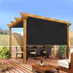 an outdoor patio with furniture and a large gray shade covering the top part of the pergolated area