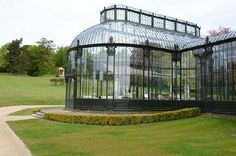 a glass house in the middle of a grassy area