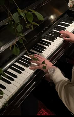 a person is playing the piano with their hands and holding it up to the keys