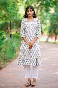 "If you are looking forward to exuding regality, check out this hand block print premium cotton A-line set. This piece is crafted with vibrence, and the design is uplifted with delicate hand block print designs laced up in the center is a perfect look for a summer day. Detail: This is 2 Pc. Set Kurta set : Cotton hand block printed kurta set  Color : White, teal & brown (Kurta).  White (Pants) Composition : 100%  Cotton (Premium quality) Length : 43 Inches (Kurta).  35 Inches (Pants) Wash care :  Hand wash separately in cold water. Do not soak and scrub. Dry in shade Model Size - Model (5'9\") is wearing size S" White Cotton Traditional Wear With Block Print, Cotton Anarkali Set With Block Print, Straight Kurta, Cotton Palazzo Set With Straight Kurta Block Print, White Straight Kurta With Printed Border, Straight Cotton Kurta With Printed Border, Cotton Straight Kurta With Printed Border, White Kurta With Printed Border In Mulmul, White Kurta With Printed Border For Diwali, Block Print Mulmul Sharara With Straight Kurta