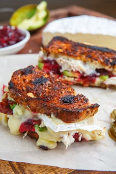 a sandwich cut in half sitting on top of a white plate next to some pickles