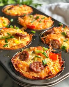 a muffin tin filled with mini pizzas covered in cheese and sausage toppings