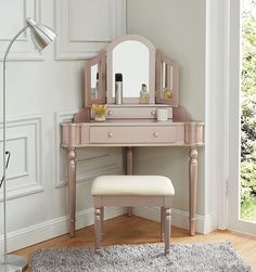 a dressing table with a stool and mirror