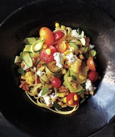 a black bowl filled with pasta and vegetables