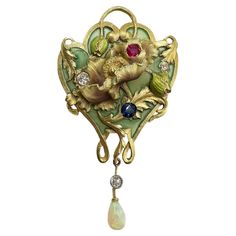 This exquisite brooch which is highly detailed depicts a poppy flower pattern in 18k yellow gold, expertly enameled in a beautiful green color and decorated with Diamond, Ruby, and Sapphire stones. The pattern takes the shape of a W and has a baroque pearl dangling from it. Early 20th Century Dimensions: 3.4 x 5.8 cm. PB: 23.10g 27850-LU3875223086842 Bijoux Art Nouveau, Art Nouveau Pendant, Nouveau Jewelry, Art Nouveau Design, Art Nouveau Jewelry, Deco Jewelry, Fine Jewels, Art Deco Jewelry, Lovely Jewellery