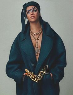 a woman with tattoos on her face wearing a green coat and gold chain around her neck