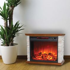 an electric fireplace is shown next to a potted plant