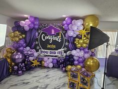 purple and gold graduation balloon arch with congratulations sign