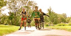 three people riding on the back of motorcycles down a road