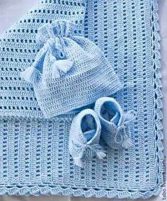 a blue crocheted blanket and pair of baby shoes