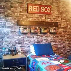 a bed room with a neatly made bed next to a red sox sign on the wall