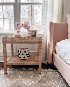 a small table with a vase on it next to a window