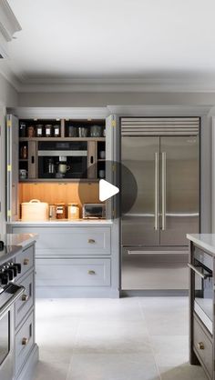 a large kitchen with stainless steel appliances and white counter tops, along with an island in the middle