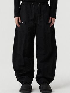 This is a trendy and casual pants made out of sturdy nylon fabric. With voluminous balloon silhouette and pocket detail on the front, it will stnd out from your casual outfit.  Balloon silhouetteFront pocket detailsAdjustable string on the waistband Oversized Parachute Pants With Pockets For Spring, Baggy Nylon Techwear Parachute Pants, Techwear Wide Leg Parachute Pants With Patch Pockets, Nylon Wide-leg Pants With Pockets, Techwear Wide Leg Nylon Cargo Pants, Nylon Cargo Parachute Pants For Work, Nylon Parachute Pants With Side Pockets For Work, Relaxed Fit Nylon Parachute Pants Techwear, Utility Style Nylon Parachute Pants For Work