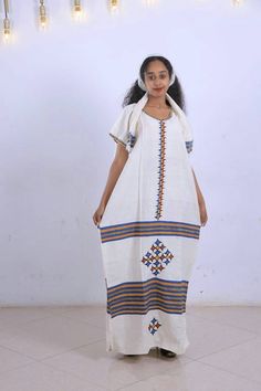 ● Beautifully and carefully made. ● 51 Inchs Long. ● 28 Inches Width. ● very Beautiful and comfortable. ● 100% Made from Cotton. ● It Comes with the Scarf/Headband (Netela) and rope belt (Mekenet) as Shown on the picture. ● Hand Wash White Dresses With Weaving Work For Traditional Ceremonies, Ceremonial White Handloom Dress, White Ceremonial Dress With Traditional Patterns, Ceremonial White Dresses With Traditional Patterns, White Dresses With Woven Motifs For Festivals, White Folk Dress With Weaving Work, Festive White Dress With Weaving Work, White Habesha Kemis For Wedding Festivals, White Habesha Kemis For Wedding And Festivals