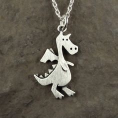 "This fierce dragon is made of sterling silver and measures about 7/8\" tall (2.2 cm). This is a larger version of our popular tiny dragon design, and the fourth photo shows the two pendants side by side. You can purchase just the pendant, or complete the necklace with a sterling silver chain.  Click here for the tiny dragon necklace:  www.etsy.com/listing/99098124/tiny-dragon-necklace  Click here for matching dragon earrings:  www.etsy.com/listing/90966724/tiny-dragon-earrings © Stick Man Creations This is our own original design, handcrafted by us, and signed on the back with our logo.   For more information about the creative process, click here:  www.etsy.com/shop/StickManJewelry/about CANADIAN ORDERS:  Please note that GST and HST are included in the price, but provincial taxes are no Fierce Dragon, Tiny Dragon, Silver Casting, Dragon Earrings, Stick Man, Jewerly Making, Dragon Necklace, Dragon Design, Silver Jewelry Handmade