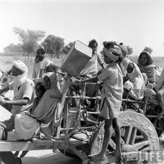 an old black and white photo of people on a cart