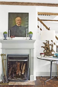 a living room with a fire place next to a painting on the fireplace mantel