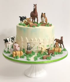 there is a cake decorated with farm animals on the top and bottom, along with horses