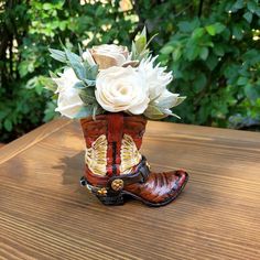 a cowboy boot with flowers in it sitting on a table