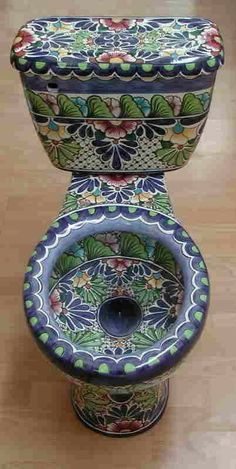 the toilet is decorated with colorful designs on it's lid and tank cover,