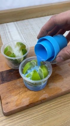 a person is squeezing limes into small cups