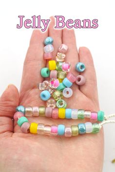 there is a hand that has some beads in it and the words jelly beans on it