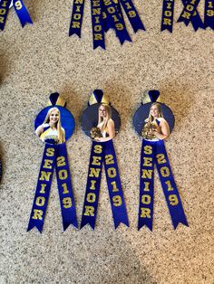 four blue ribbons with pictures of two women and one man on them are laying on the floor