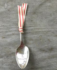 a silver spoon with a red and white ribbon on it