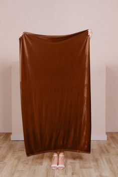 a woman standing in front of a brown blanket