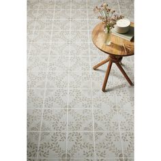 a table with flowers on it in front of a white tiled wall and flooring