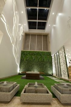 an indoor living room with artificial grass and stone seating area in front of the wall