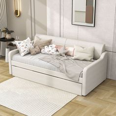 a white couch with pillows on top of it in front of a wall mounted mirror