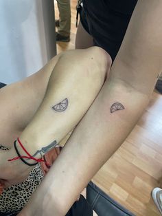 two women with matching tattoos on their legs