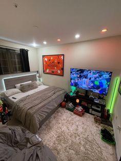 a bed room with a neatly made bed and a flat screen tv on the wall