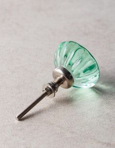 a green glass object with a screw in it