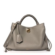 This is an authentic MULBERRY Heavy Grain Iris Tote in Grey.  This stylish satchel is crafted of luxurious leather in grey.  The bag features a braided leather handle with gold links, an optional shoulder strap, and gold hardware. The top is open to a beige suede interior with zipper and patch pockets. Luxury Gray Top Handle Satchel, Luxury Everyday Gray Satchel, Luxury Gray Everyday Satchel, Gray Leather Bag With Gold-tone Hardware, Gray Leather Bag, Winter Handbag, Grey Purse, Winter Handbags, Grey Bag