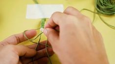 a person is making something with yarn on the table