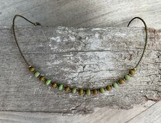 ✦Delicate and eye catching, gorgeous Czech glass matte opaque beads in various autumn green tones, single strand short necklace. The 17 main beads are capped and between all beads are tiny brass seed beads which continue to back of necklace, attached by a clasp and extension chain. The necklace is a delight. ✦Bead sizes vary from 6mm to 5mm. Seed beads at back 1.5mm. ✦Length of necklace 42cm (16 1/2") approximately, plus a 6cm (2 1/2") extension chain. ✦ I have created this piece with inspiratio Earthy Green Necklace For Festival, Earthy Green Necklace For Festivals, Green Necklaces With Spacer Beads For Festivals, Green Necklace With Spacer Beads For Festivals, Earthy Green Beaded Necklace For Gift, Adjustable Czech Glass Necklaces For Festivals, Adjustable Czech Glass Necklace For Festivals, Green Festival Necklace With Spacer Beads, Bohemian Green Necklaces With Tiny Beads