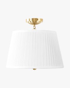 a light fixture with a white shade on the top and gold trimming around it