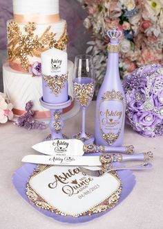 purple and gold wedding cake with wine glasses, champagne bottle and knife on table next to flowers