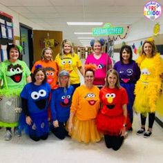 a group of people dressed in costumes posing for a photo with sesame street characters behind them