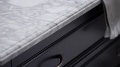 a white marble counter top sitting on top of a black dresser