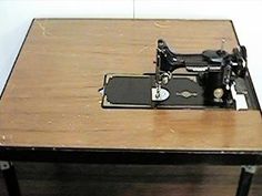 a sewing machine sitting on top of a wooden table next to a black and white object