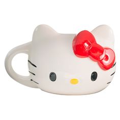 a white hello kitty mug with a red bow on it's head and eyes